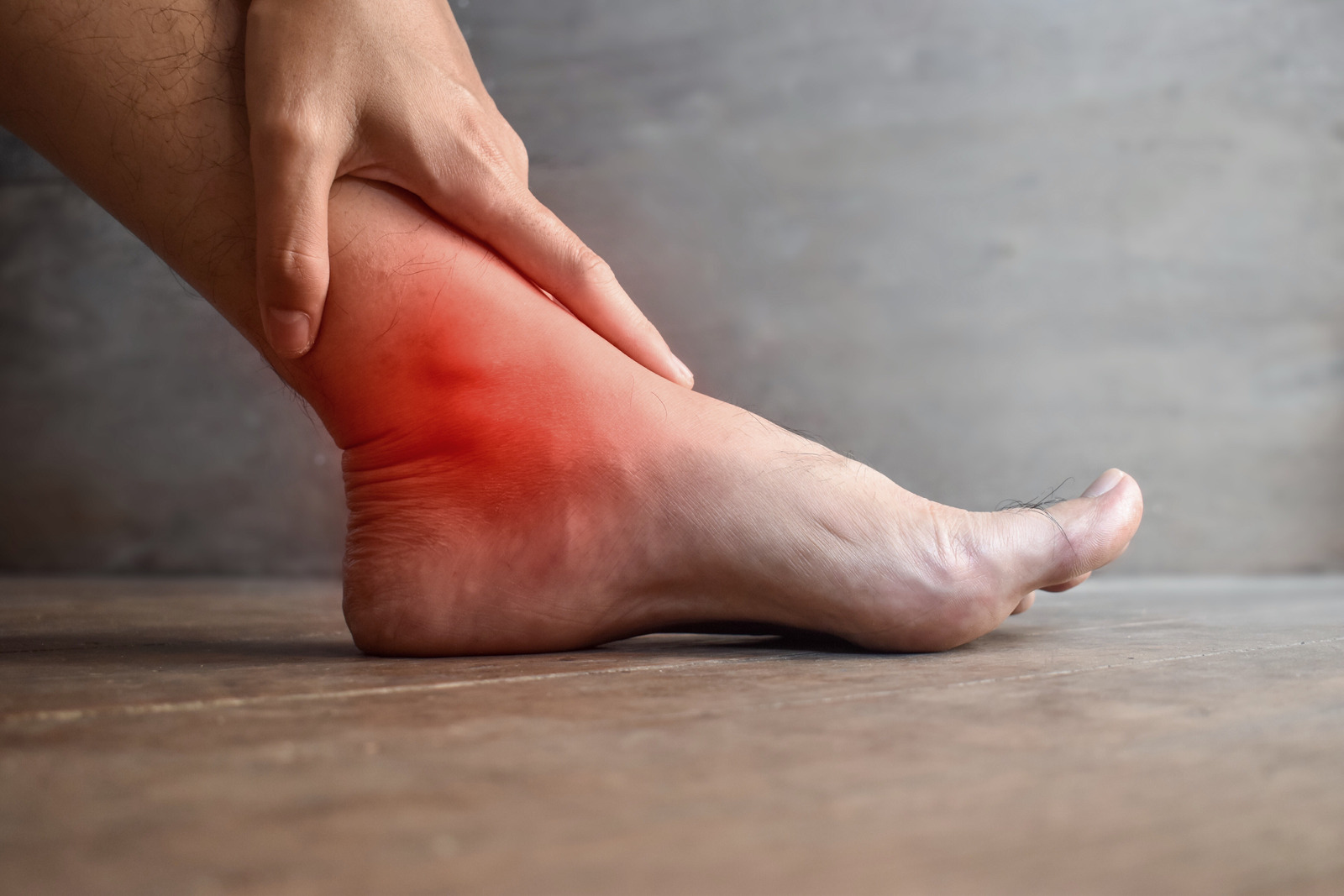 Inflammation of Asian mans ankle joint and foot. Concept of joint pain, osteoarthritis or gout.