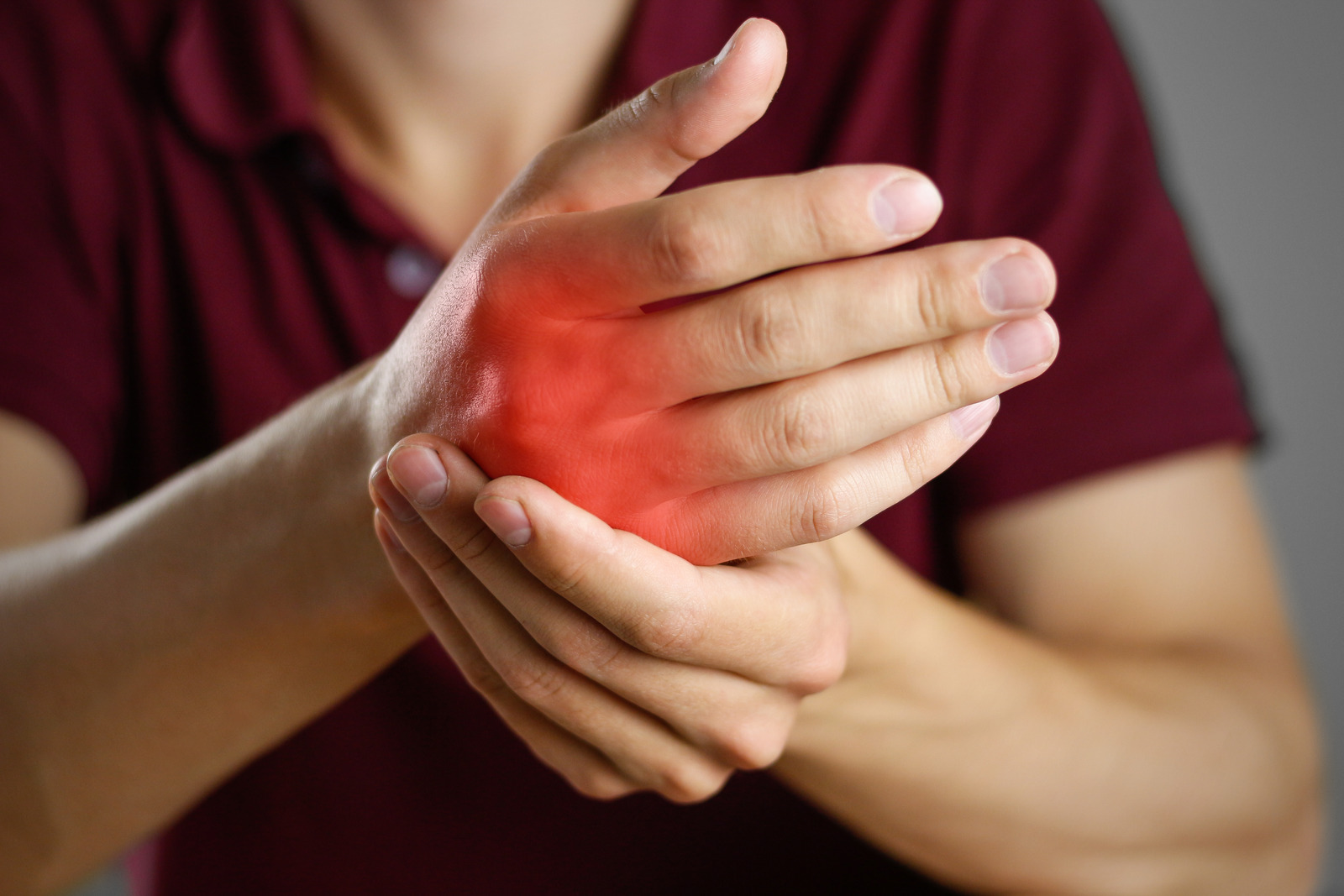 The guy hurts his hand. The pain in his fist. Closeup. The lesion is highlighted in red.